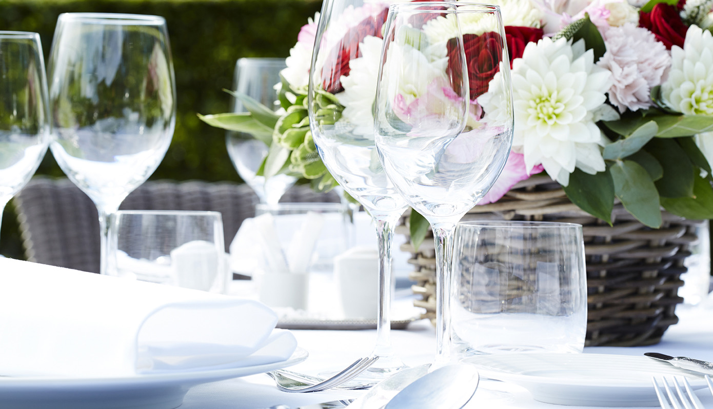 Gedekte tafel met zomerse bloemen en glaswerk